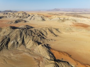 Arid plains, sand dunes and bare mountain ridges in the Tsondab Valley in the Namib Desert. Aerial