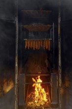 Smoking fish over beechwood fire in large metal smoker oven on the island Usedom in the Baltic Sea,