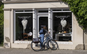 Woman looking through the window pane of a closed flower shop, Potsdam, Brandenburg, Germany