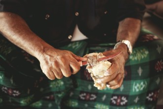 Traditional camel restaurant in Salalah, a guest eats a piece of boiled camel, Dhofar, Oman