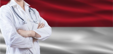 Doctor with crossed arms on Monaco flag. Monaco health and care concept. Female doctor on Monaco