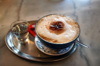 Cappuccino with a glass of water on a silver tray, Erlangen, Middle Franconia, Bavaria, Germany