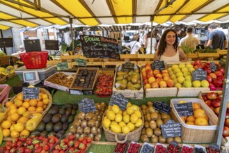 Vendor at her stall selling fruit at the market in La Rochelle, France