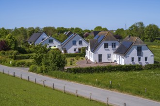 Detached houses with photovoltaics on the roof, landscape on the dyke, Tammensiel, Pellworm Island,