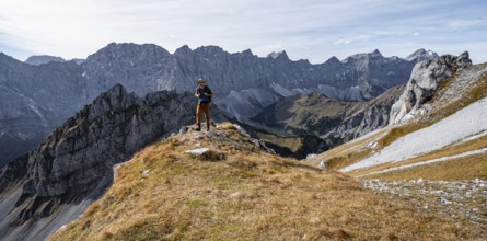 Mountaineers in front of a picturesque mountain landscape in autumn, view of the rocky ridge of the