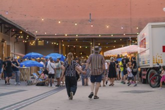 Lively scene at an evening event with many people and colourful lights, 950 years Weil der Stadt