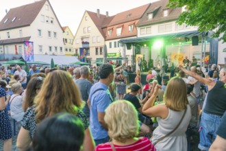 Lively scene of a summer concert with people dancing outdoors, 950th anniversary of Weil der Stadt,