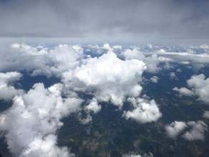 View from aeroplane at high altitude of white bright cluster clouds Altocumulus above darker