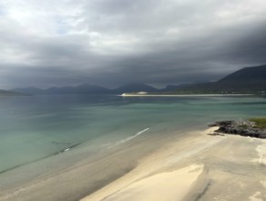 Stormy coastal view with grey sky and calm sea to the shore of a wide bay, Outer Hebrides, Isle of