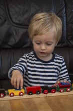 JBlond boy, 2 years old, playing with toy train in Ystad, SkÃ¥ne County, Sweden, Scandinavia