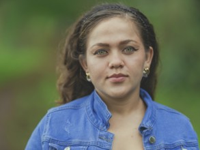 Portrait of attractive latin girl smiling outdoors. Close up of Latin American girl face looking