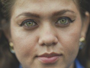 Close up of Latin American girl face looking and smiling at the camera. Portrait of attractive
