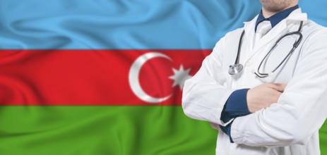 Azerbaijan healthcare concept. Male doctor on Azerbaijan flag. Doctor with crossed arms on