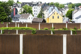 A row of noise barriers in front of a residential area at the Sonnborn junction in Wuppertal,
