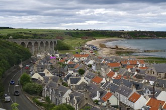 Coastal town with a viaduct and orange tiled roofs under a cloudy sky, Portsoy, Aberdeenshire,