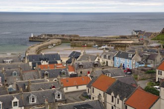 Harbour town with view of rooftops and boats in a small harbour basin by the sea, Portsoy,