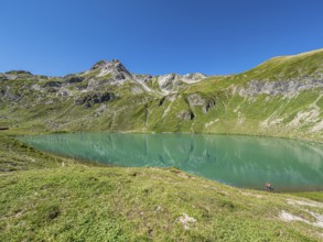 Hiker at lake Engeratsgundsee, mountain range between Oberstdorf and Bad Hindelang, Allgaeu,