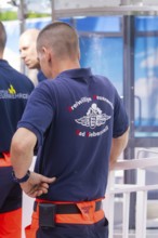 Close-up of firefighters in blue and orange uniforms standing together, fire brigade exercise for