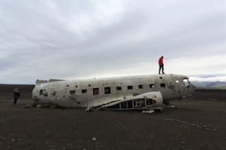 Tourist on aircraft wreckage, US Navy Douglas DC-3 transport plane, Sander, volcanic landscape,