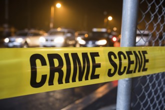 Close up of yellow crime scene tape in street with cars in blurry background. Generative ai, AI