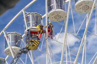 Workers in climbing gear carry out a rescue operation on the Ferris wheel, fire brigade exercise
