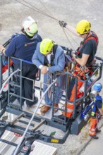 Firefighters secure person on lifting platform during rescue operation, Fire brigade exercise for