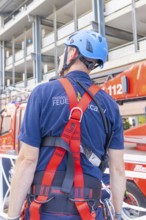 Fire brigade employee with safety equipment looking at a vehicle, fire brigade exercise for gondola
