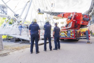 Firefighters look at an emergency situation on a Ferris wheel with a lifting platform, Fire brigade