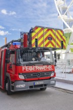 Fire engine with lifting mechanism parked in an urban environment, fire brigade exercise for