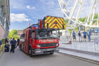Fire brigade crew prepares operation on a Ferris wheel in front of a blue sky, Fire brigade