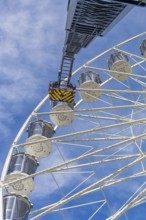 Fire brigade ladder extends against the sky to the cabins of the Ferris wheel, ready for a rescue,