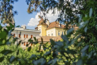Beautiful building visible through trees under a sunny sky, Merano, South Tyrol, Italy