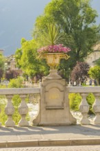 Stone bridge with decorative flower pot, inscription 1909, sunny day, Merano, South Tyrol, Italy