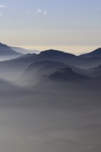 Mountain silhouettes... Alpine peaks and mountain ranges in the Bavarian Alps, light fog rises from