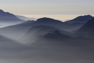 Mountain silhouettes... Alpine peaks and mountain ranges in the Bavarian Alps, light fog rises from