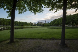 Schwerin Castle in the distance, framed by the symmetrical rows of trees in the castle garden,