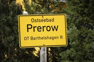 A yellow sign with the inscription Baltic resort Prerow in front of green trees, Prerow,