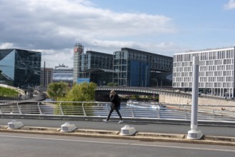 Modern city view with glass buildings, bridge and river under a cloudy sky, Berlin Central Station,