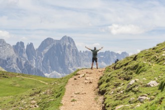 Person with raised arms on a hiking trail in front of an impressive mountain panorama, Schlehrn