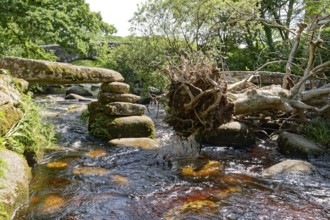 Remains of an old stone bridge and the new bridge on the East Dart River in Dartmoor National Park.