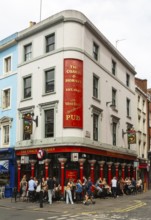 People sitting outside The Coach and Horses pub, Romilly Street, Soho, London, England, UK
