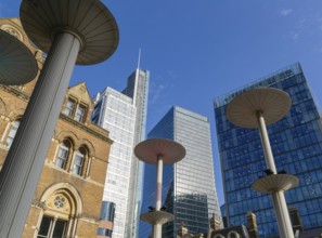 Looking up at office blocks in blue sky from forecourt of Liverpool Street station, London,