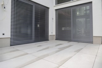 Modern terrace with large, light-coloured terrace tiles on a new detached house