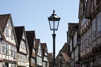 Street with half-timbered houses and historic street lamp in the old town centre, Celle, Lower