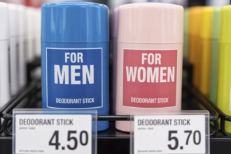 Close-up of gender-labeled deodorant sticks with unequal prices. Illustration of the pink tax in