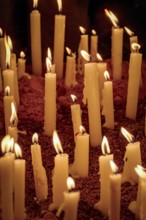 Candles burning on the dirt floor during a typical Brazilian religious festival, Minas Gerais,