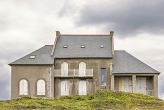 Old house with closed window shutters on a hill at a coastal area, Camaret-sur-Mer, Crozon