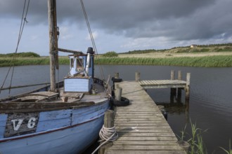 Old blue fishing boat moored at wooden jetty, RingkÃ¸bing Fjord, old fishing village Nymindegab,