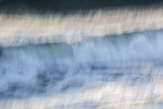 Dynamic waves with a blurred effect create a feeling of movement on the sea, near Hvide Sande,