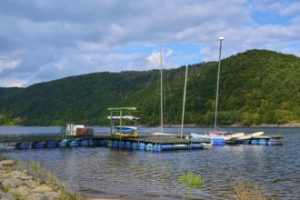 Jetty with boats in front of wooded hills and clouds, summer, Rursee, Rurberg, Simmerath, Eifel
